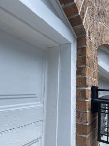 Close up view of white garage door with brick archways