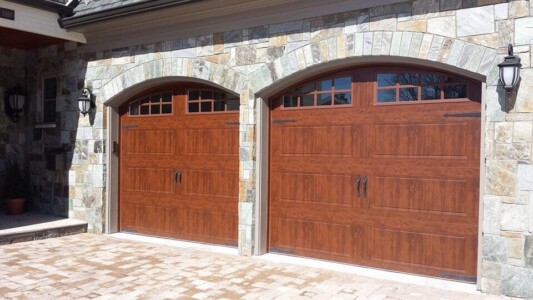 Garage with two wooden doors with stone archways