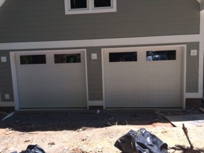 Newly installed white garage doors with windows by American Joe Garage